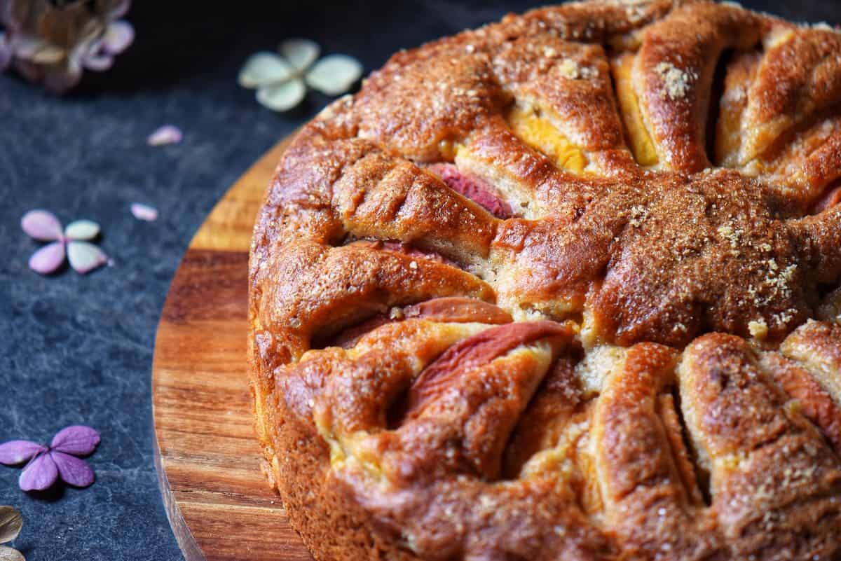 An overhead view of a cake made with sliced peaches. 