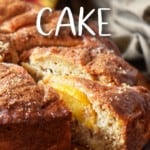 A slice of peach cake being removed from a cake.