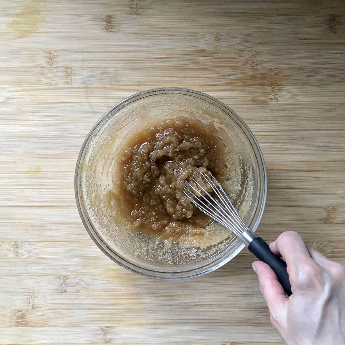 Brown sugar and oil being whisked together. 