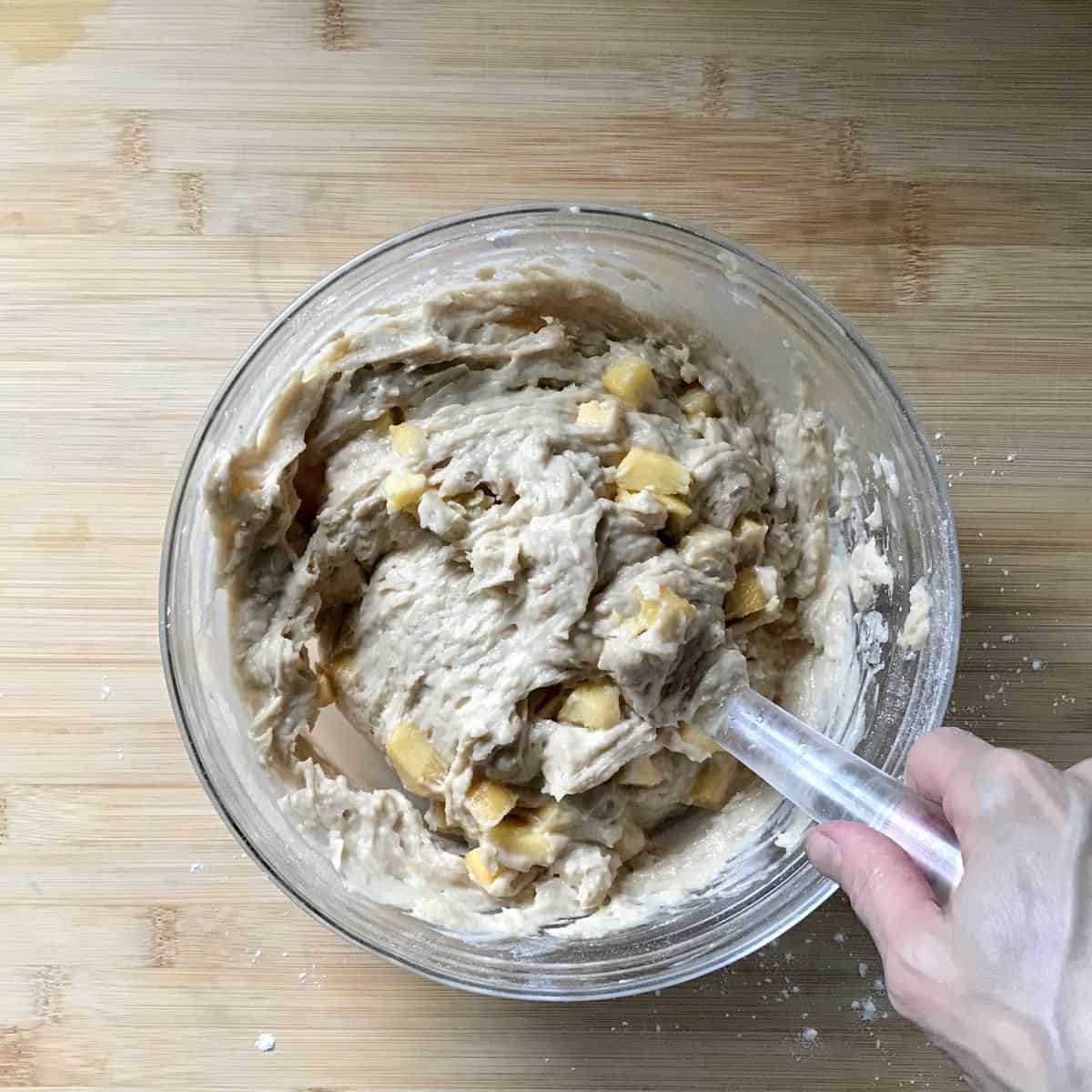 The wet and dry ingredients being mixed together in a bowl. 