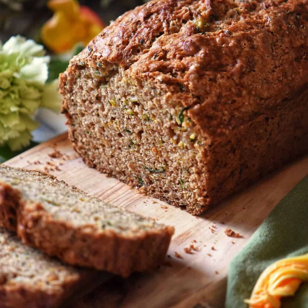 Sliced zucchini bread on a wooden board.