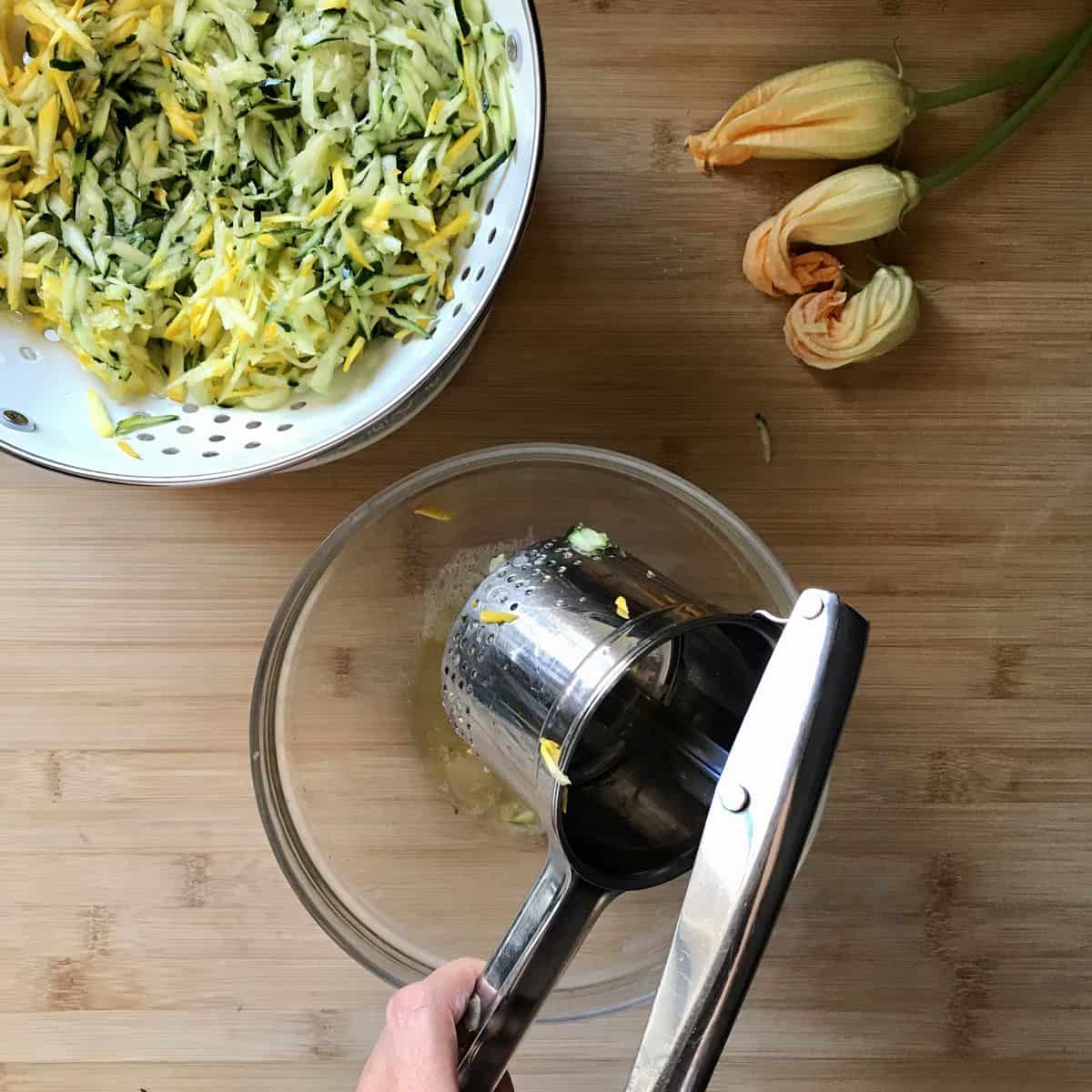 A potato ricer used to squeeze out excess moisture from zucchini.