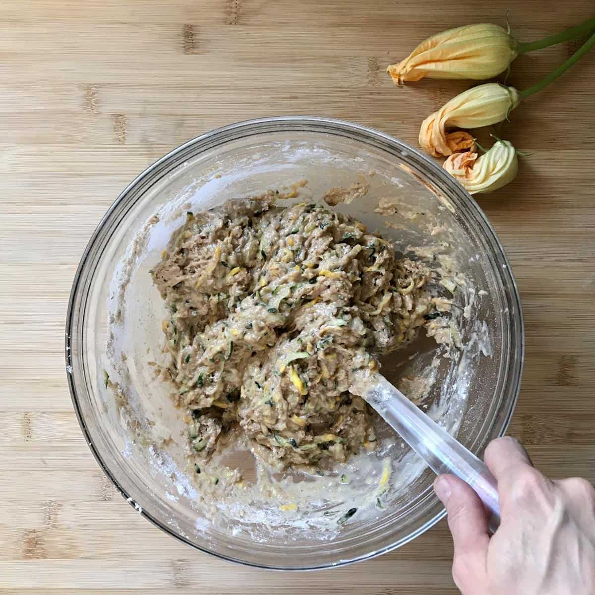 Wet and dry ingredients are combined to make a healthy zucchini bread recipe.