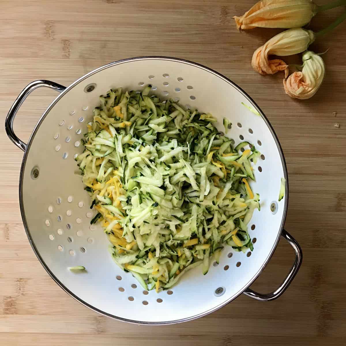 Grated zucchini in a colander.