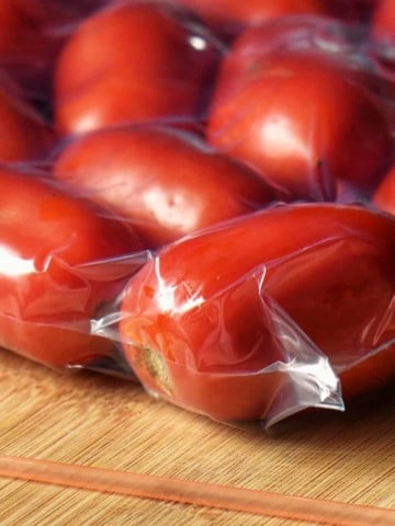Frozen whole tomatoes in a freezer bag.