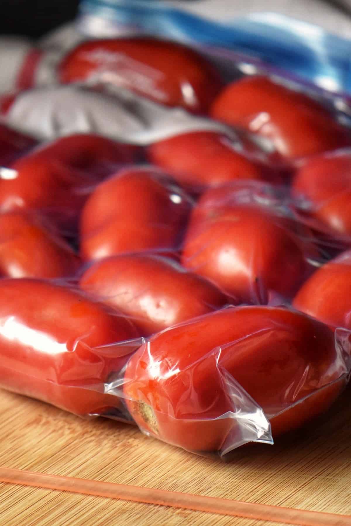 Packed tomatoes in a plastic zip lock bag, ready to go in the freezer.