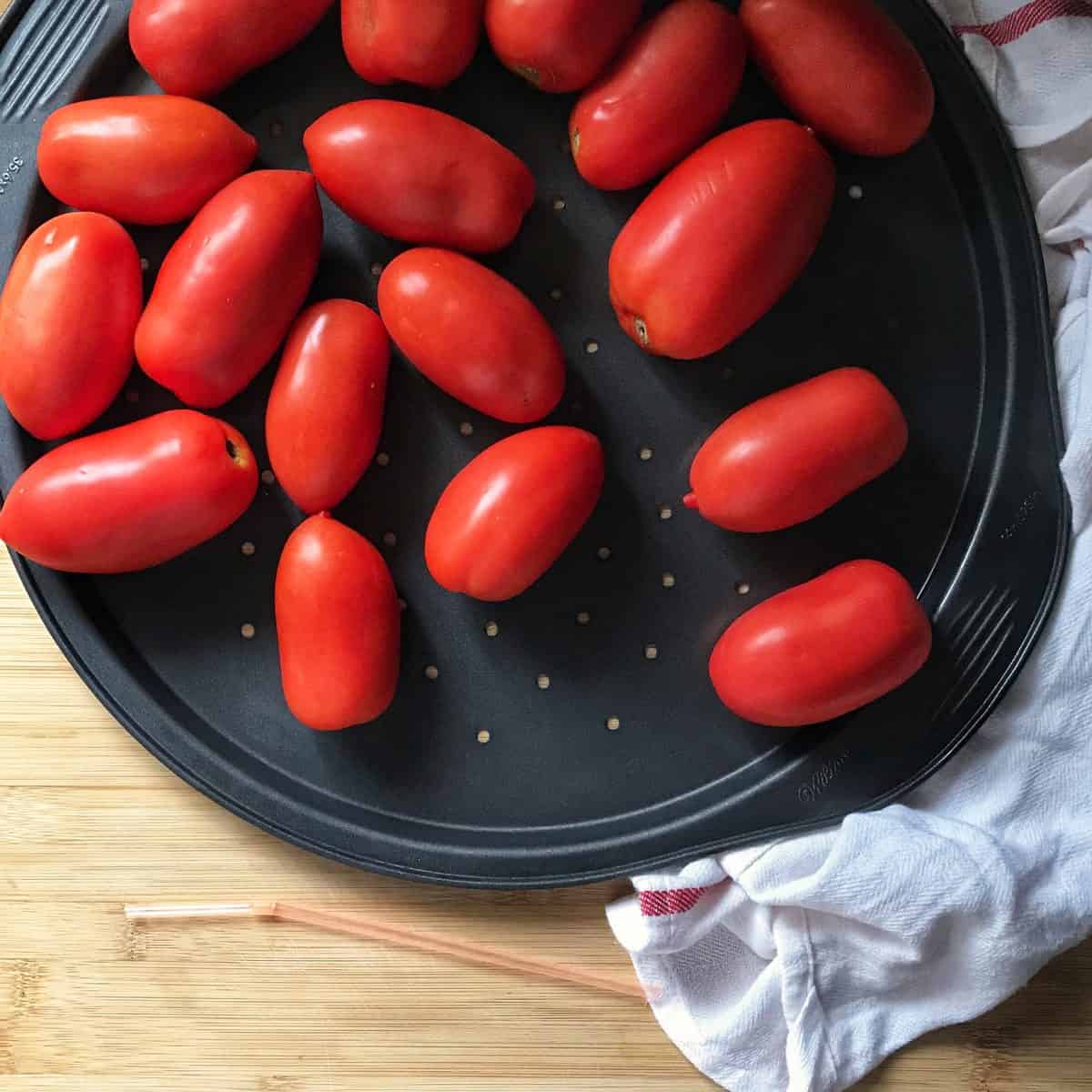 Frozen whole tomatoes on a sheet pan.