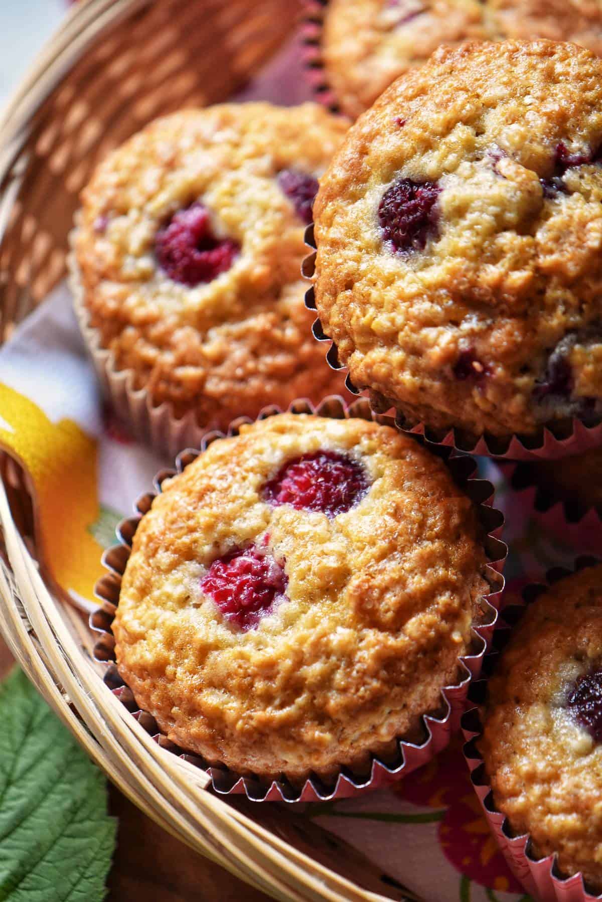 A few raspberry muffins in a wicker basket.