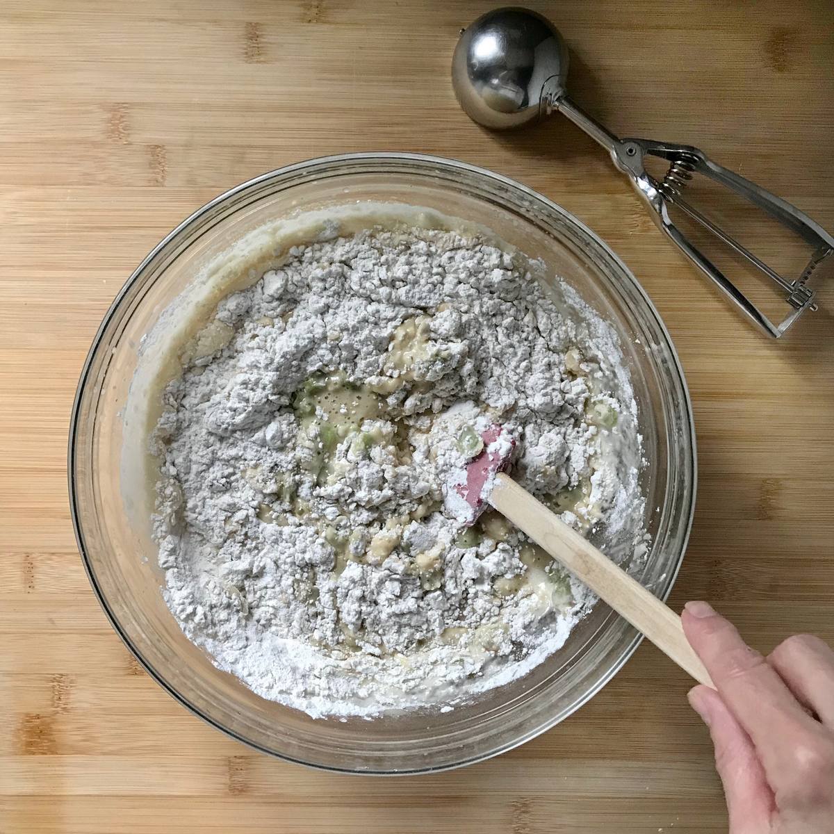 The wet and dry ingredients to make muffins are combined in a bowl.