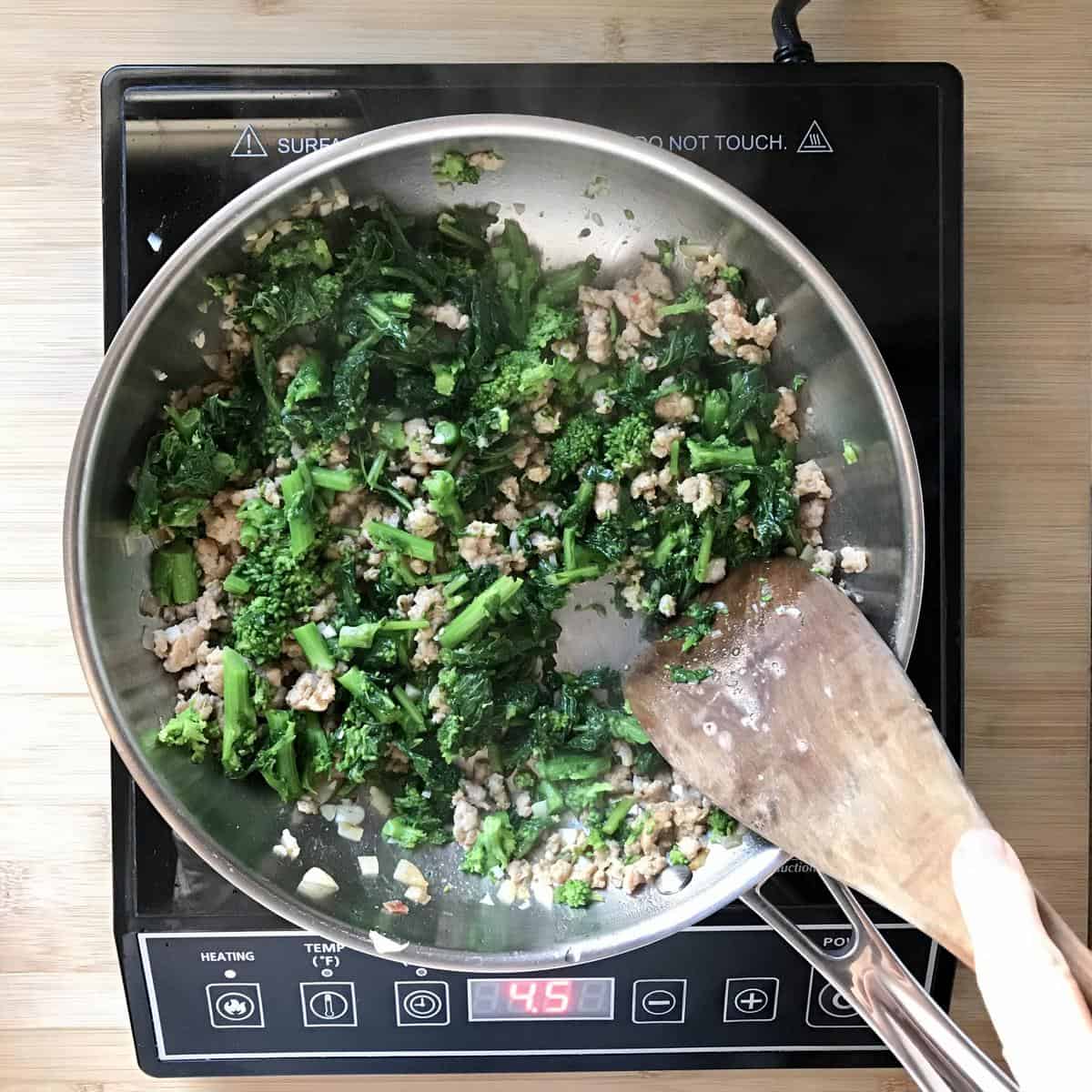 Italian broccoli rabe combined with sausage in a pan. 