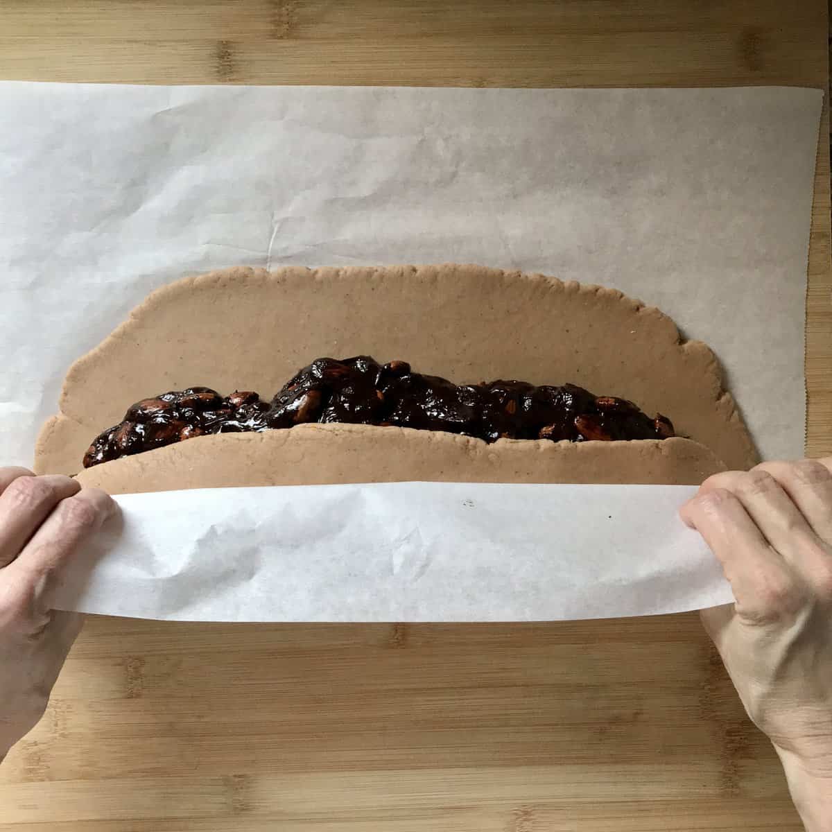 Almond chocolate filling is beign covered with cookie dough.