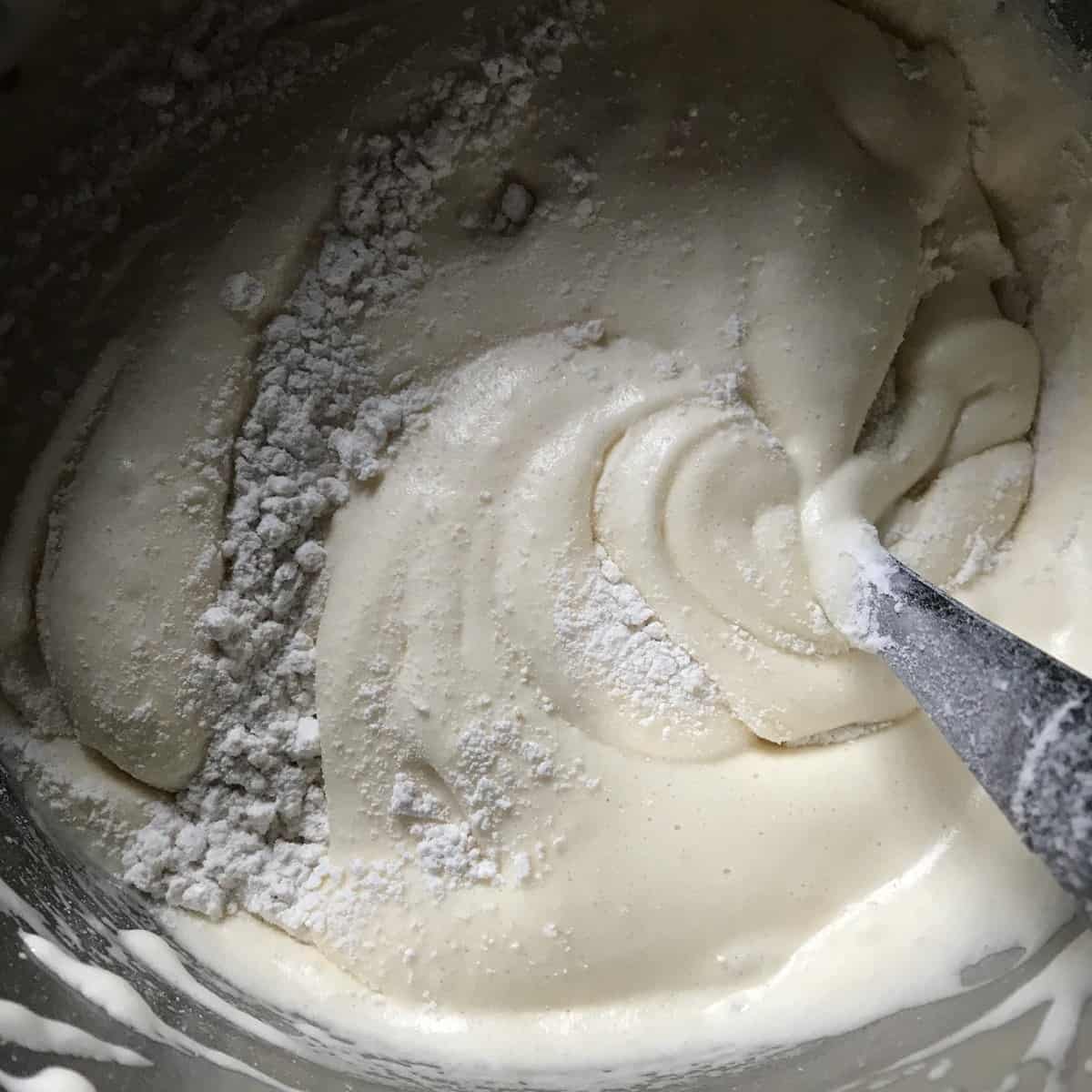 Flour being incorporated in the egg mixture.