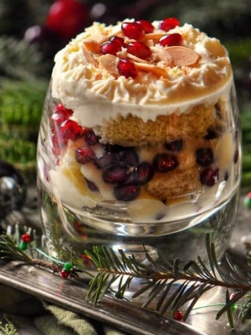 Zuppa Inglese in a glass topped with whipped ricotta on a silver platter.