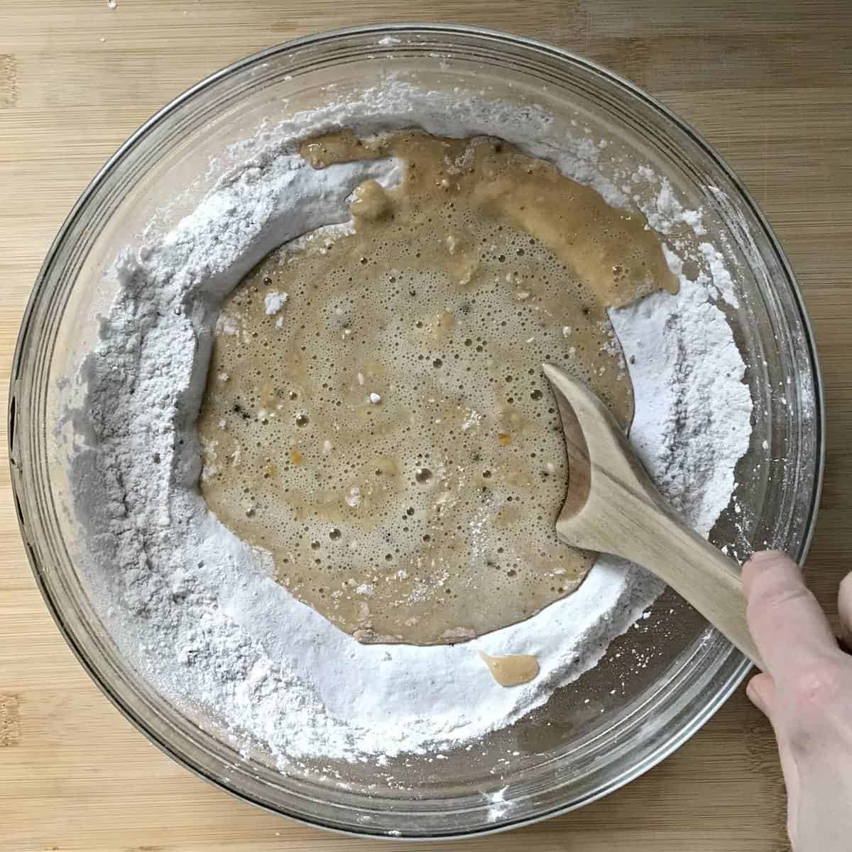 Wet and dry ingredients to make biscotti being combined in a bowl. 