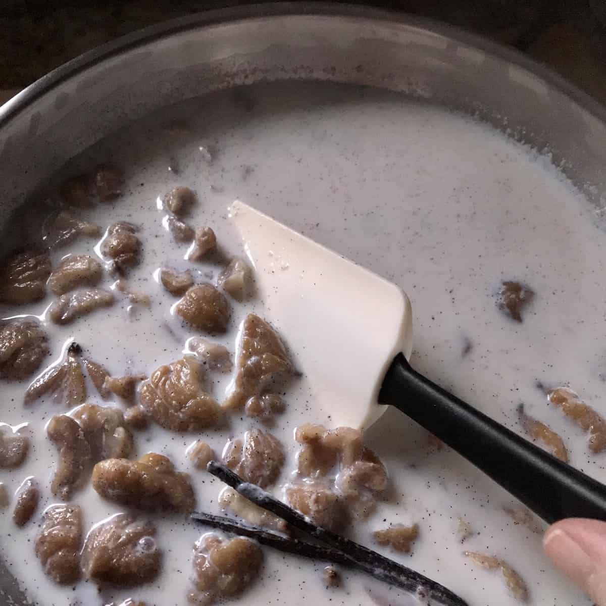 Chestnuts being simmered with milk in a saucepan.
