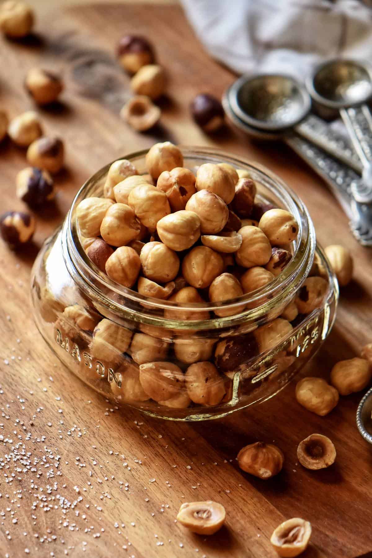 Skinned and roasted hazelnuts in a mason jar.