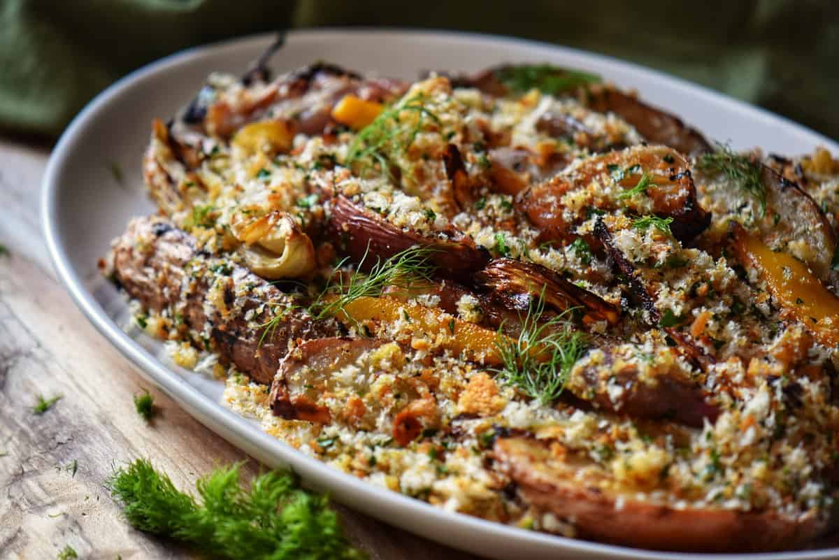 Roasted potatoes and fennel in a white serving platter.