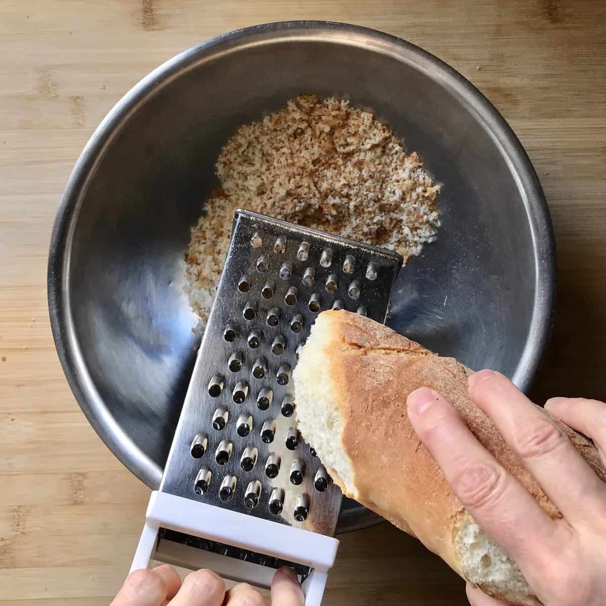 Day old bread in teh process of being grated.