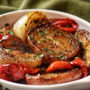 Roasted Red Potatoes, caramelized onions and roasted bell red peppers in a white dish.