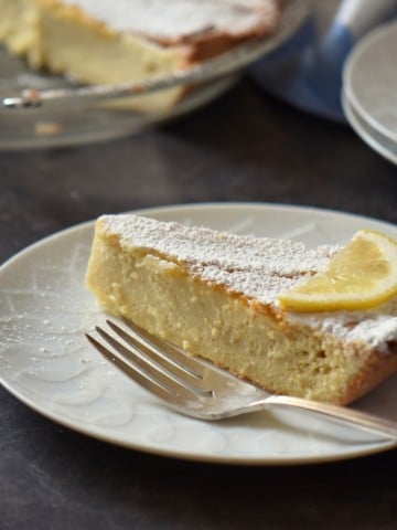 A slice of ricotta pie on a white plate.