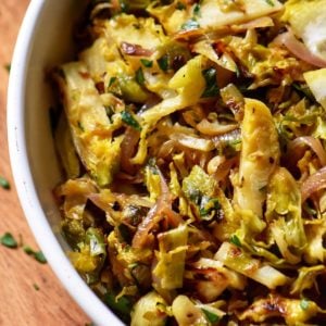 Shaved brussels sprouts in a white bowl.