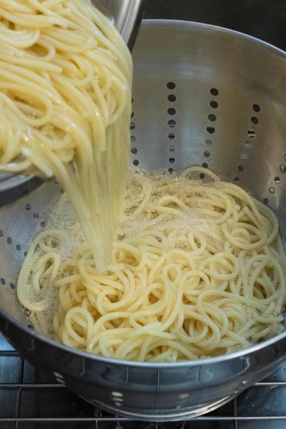 Spaghetti being drained in a colander.