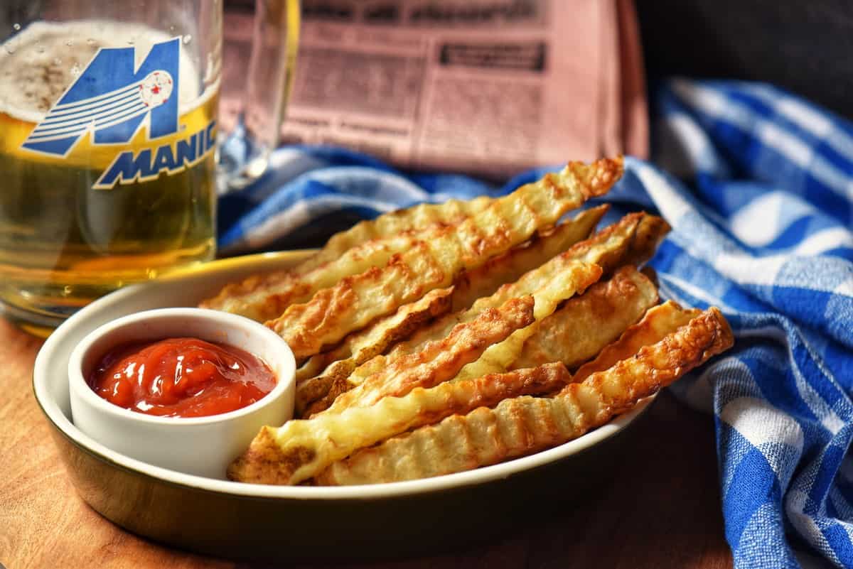 Crinkle cut fries with a small dish of ketchup.