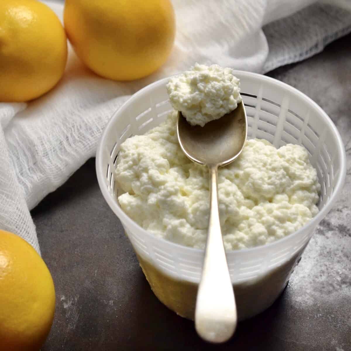 A spoon of homemade ricotta on a cheese basket.