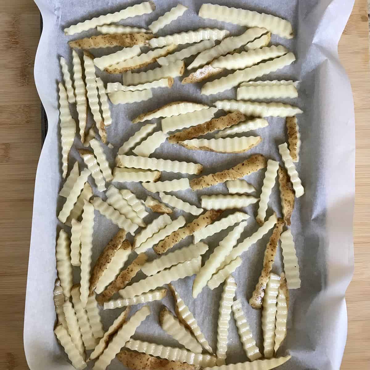 Wavy cut french fries on parchment paper. 