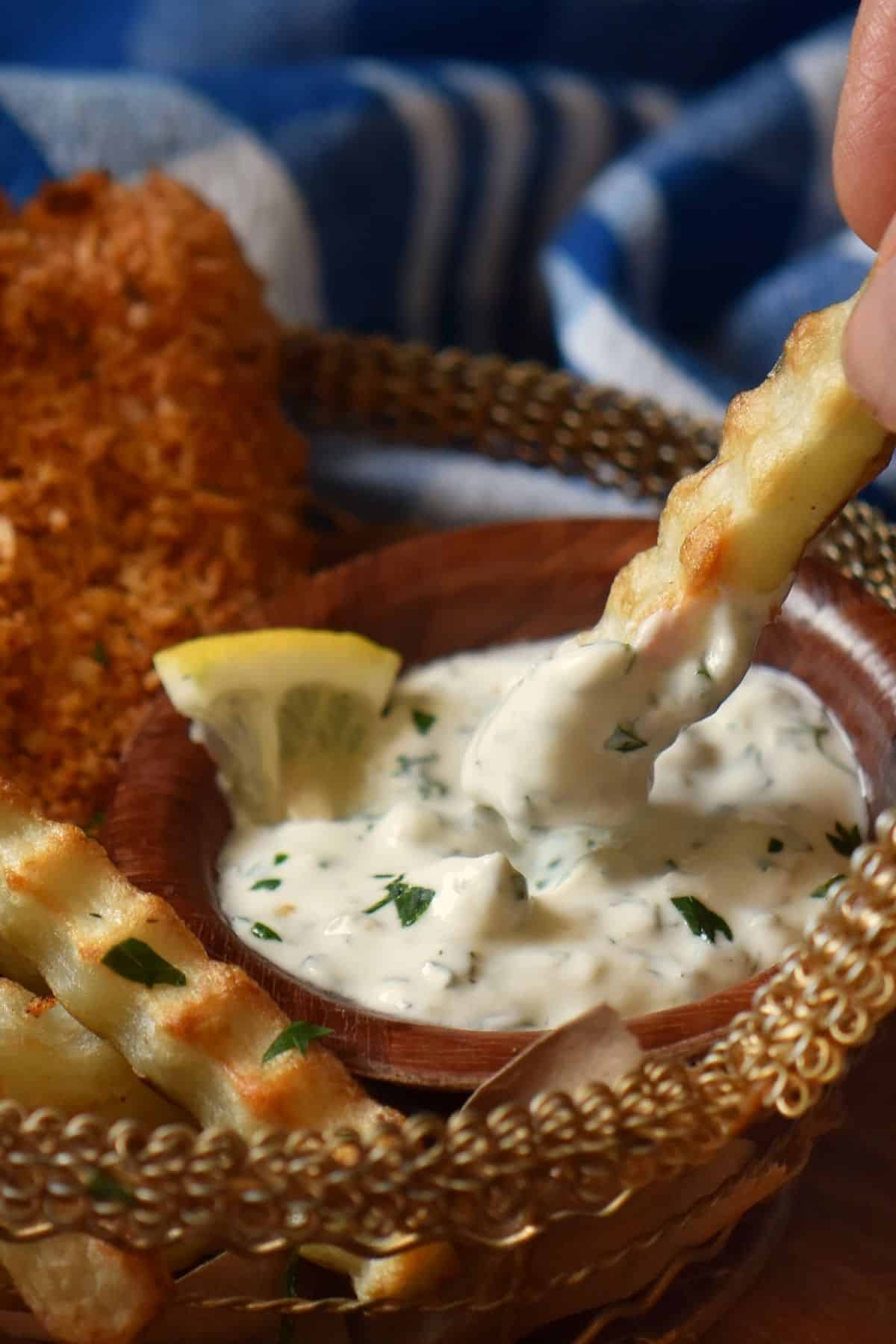 An air fryer crinkle fry dipped into a Greek yogurt sauce without mayo.