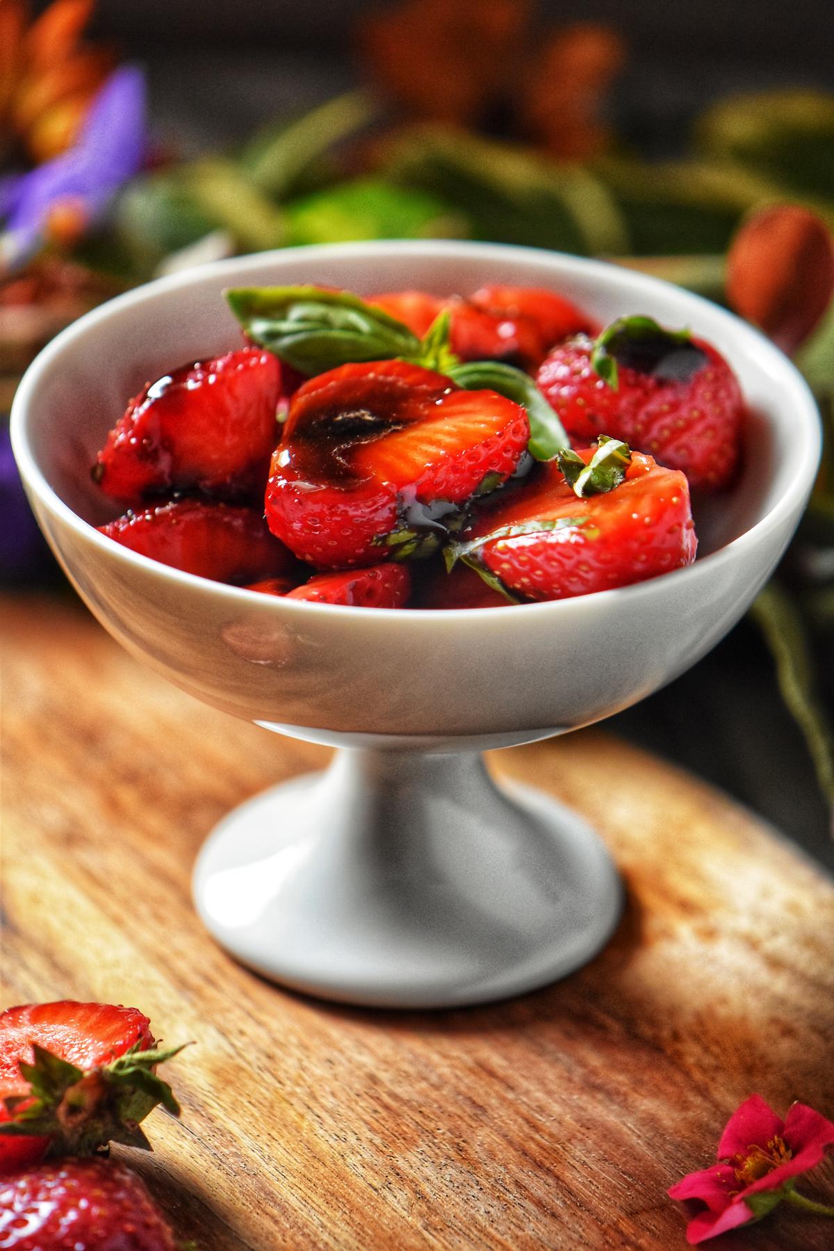 Balsamic strawberries in a white bowl.