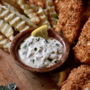 A no mayo tartar sauce in a bowl next to air fryer fish and chips.