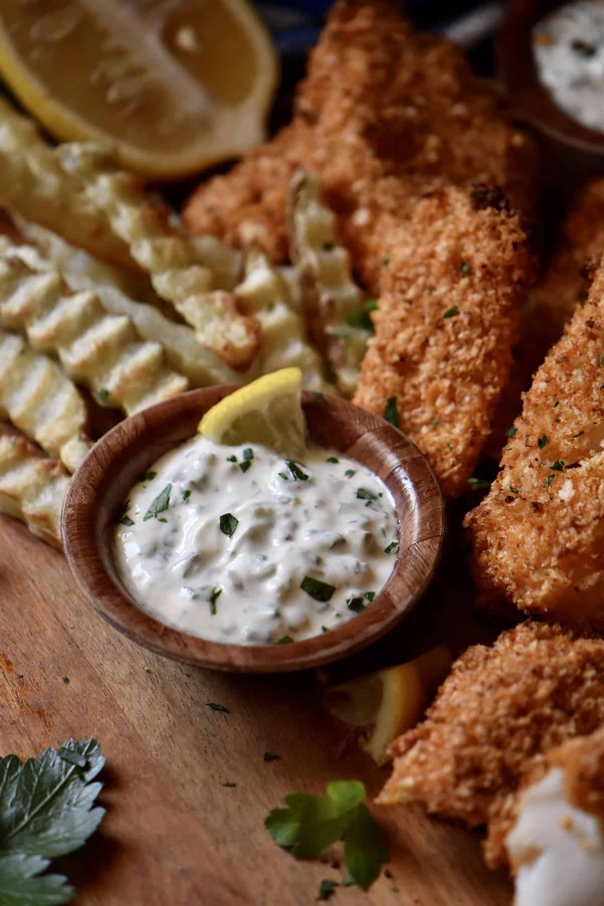 A no mayo tartar sauce in a bowl next to air fryer fish and chips.