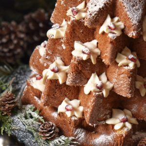 A Pandoro Christmas tree cake garnished with whipped ricotta and icing sugar.