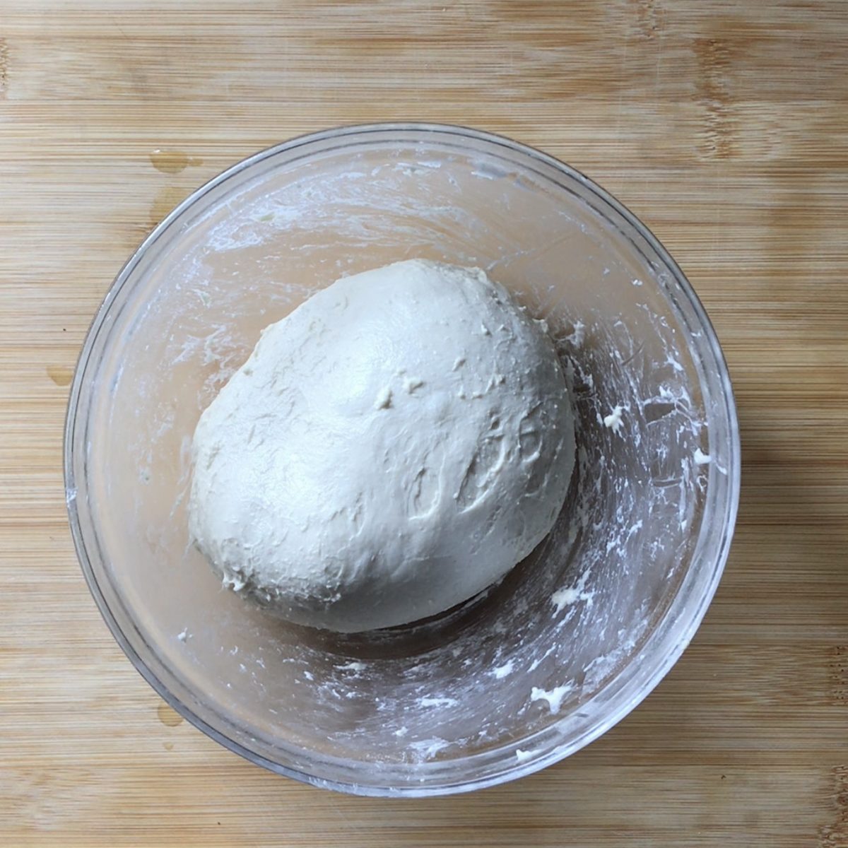 A round ball of focaccia dough in a bowl.