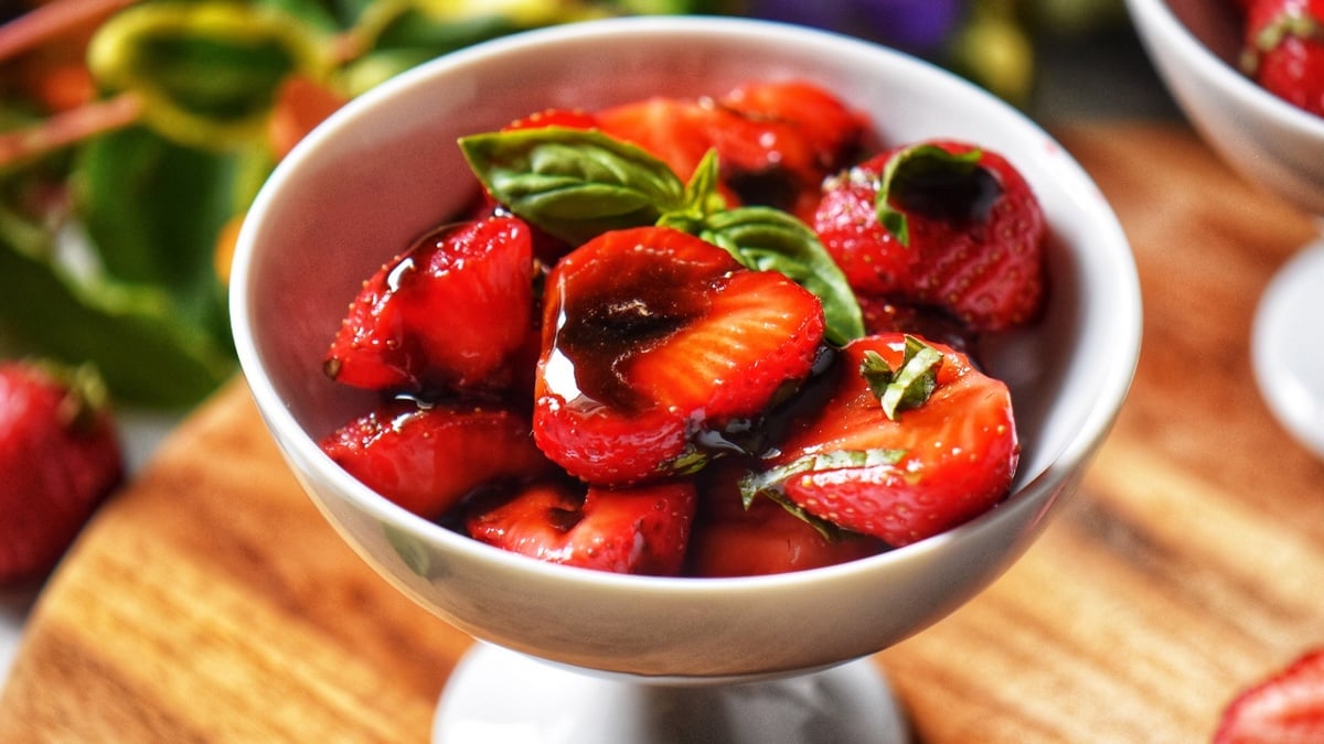 Balsamic strawberries in a white bowl.