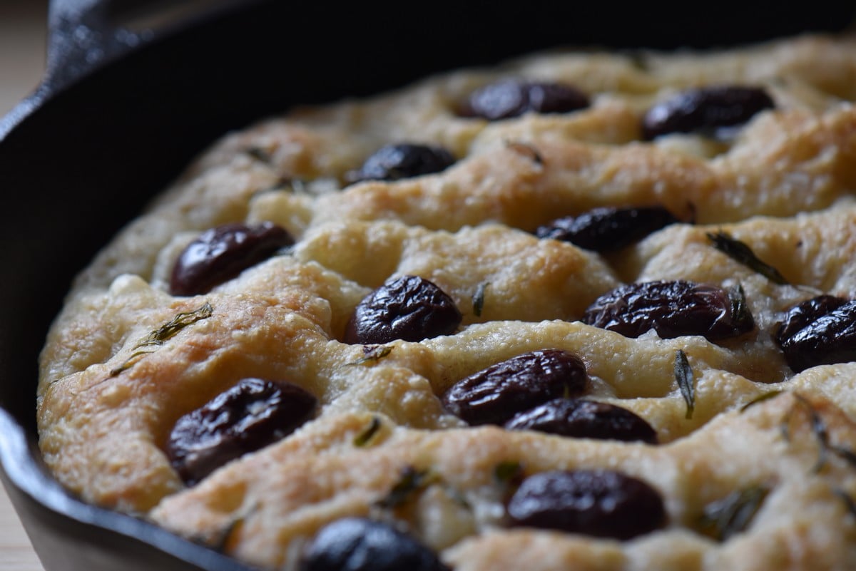 Olive focaccia with thyme in a cast iron skillet.