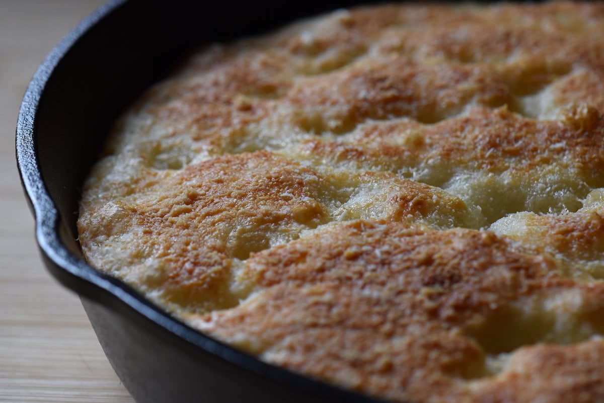 Parmesan focaccia in a cast iron skillet.