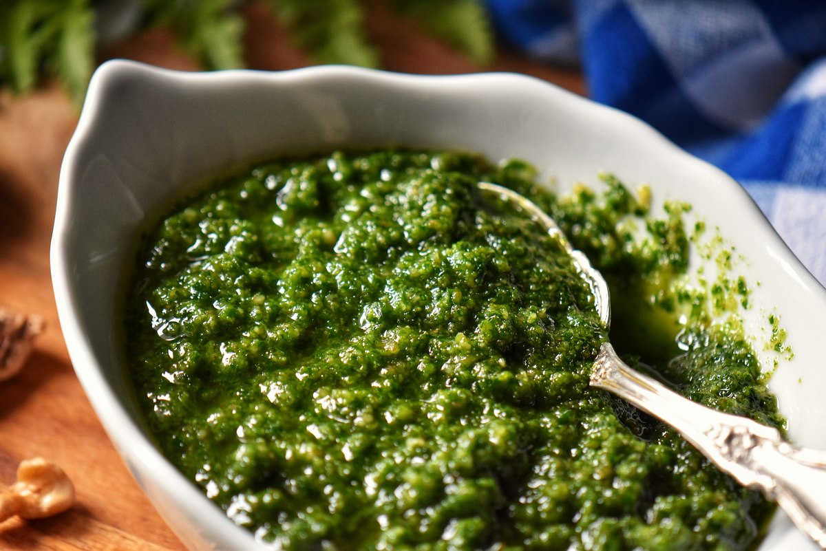 A close up photo of the coarse texture of parsley pesto.