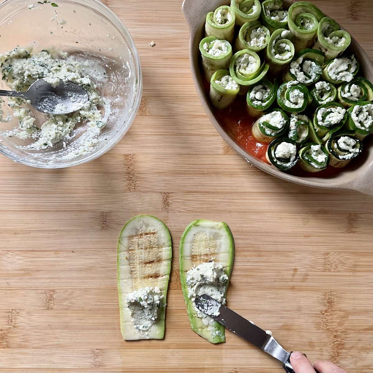 Ricotta filling being spread on grilled zucchini.