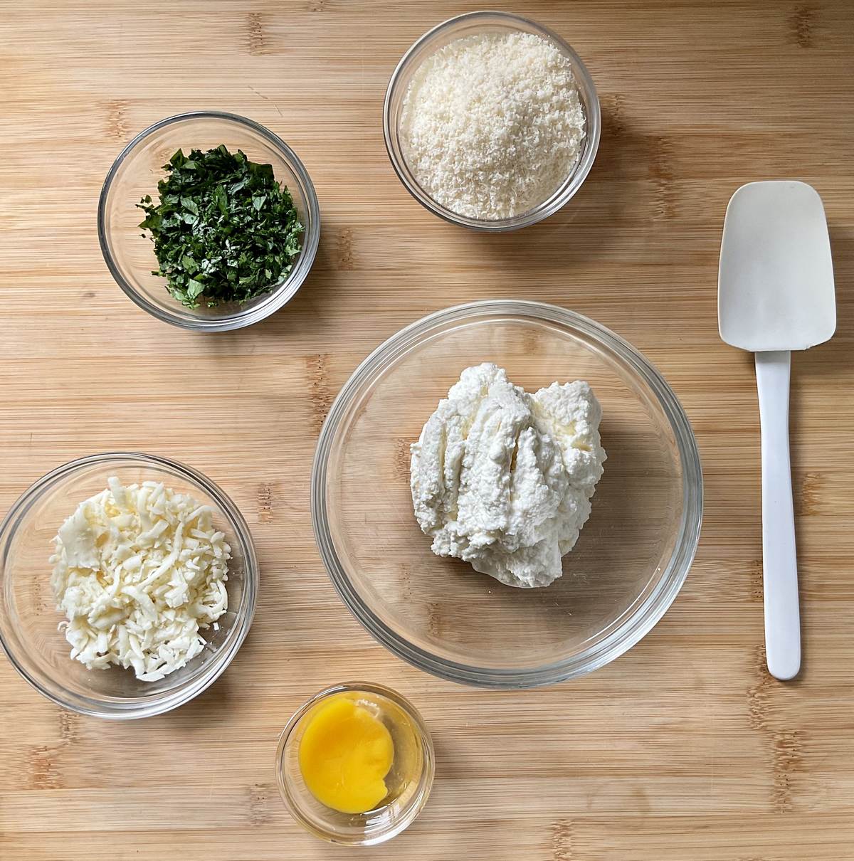 Ingredients to make ricotta filling in separate bowls.