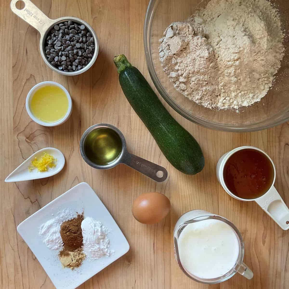 Flat lay of dry and wet ingredients prepared for zucchini muffins.