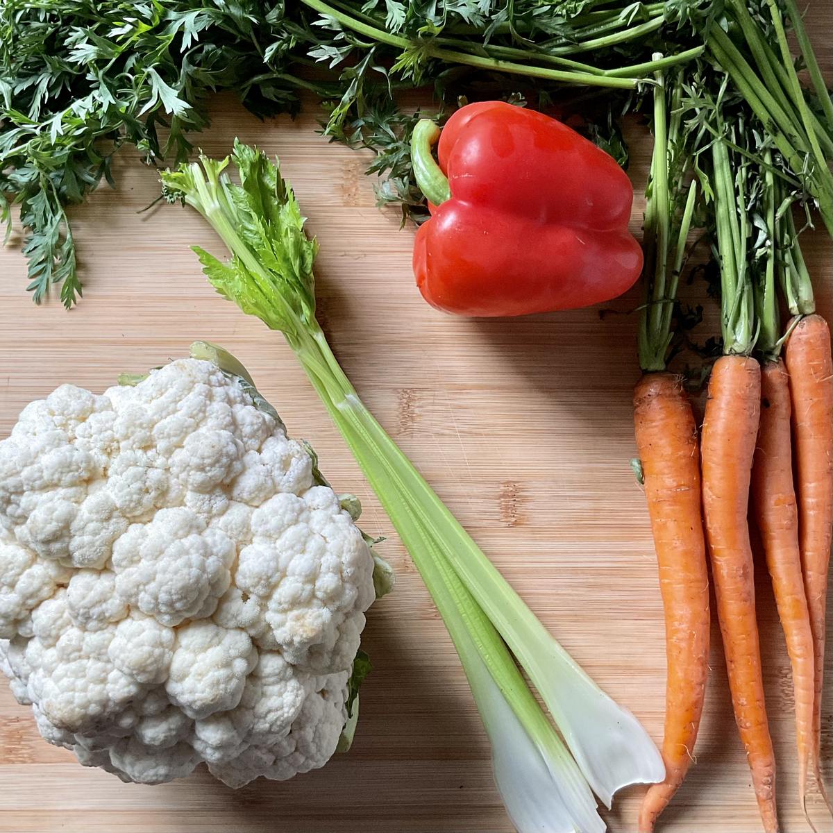 Ingredients to make giardiniera on a wooden board.