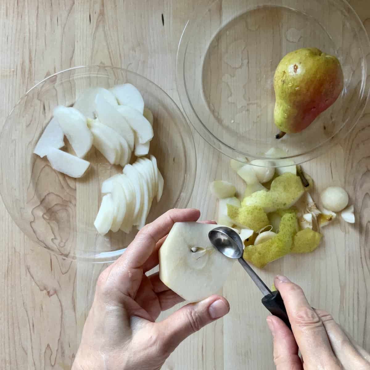 Removing the core of a pear with a melon baller..