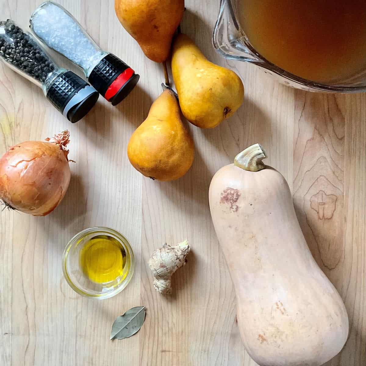 Ingredients to make butternut squash soup on a cutting board.