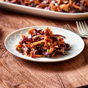 Red cabbage slaw on a white plate.