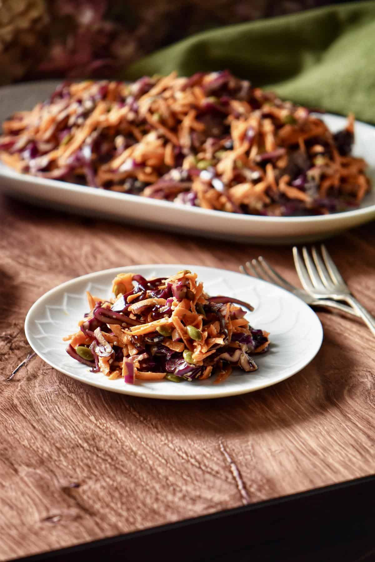 A derving of red cabbage slaw on a white plate.