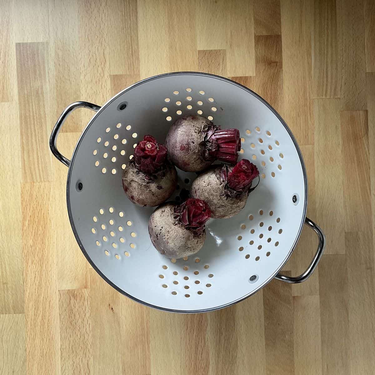 Clean and trimmed beets in a colander.