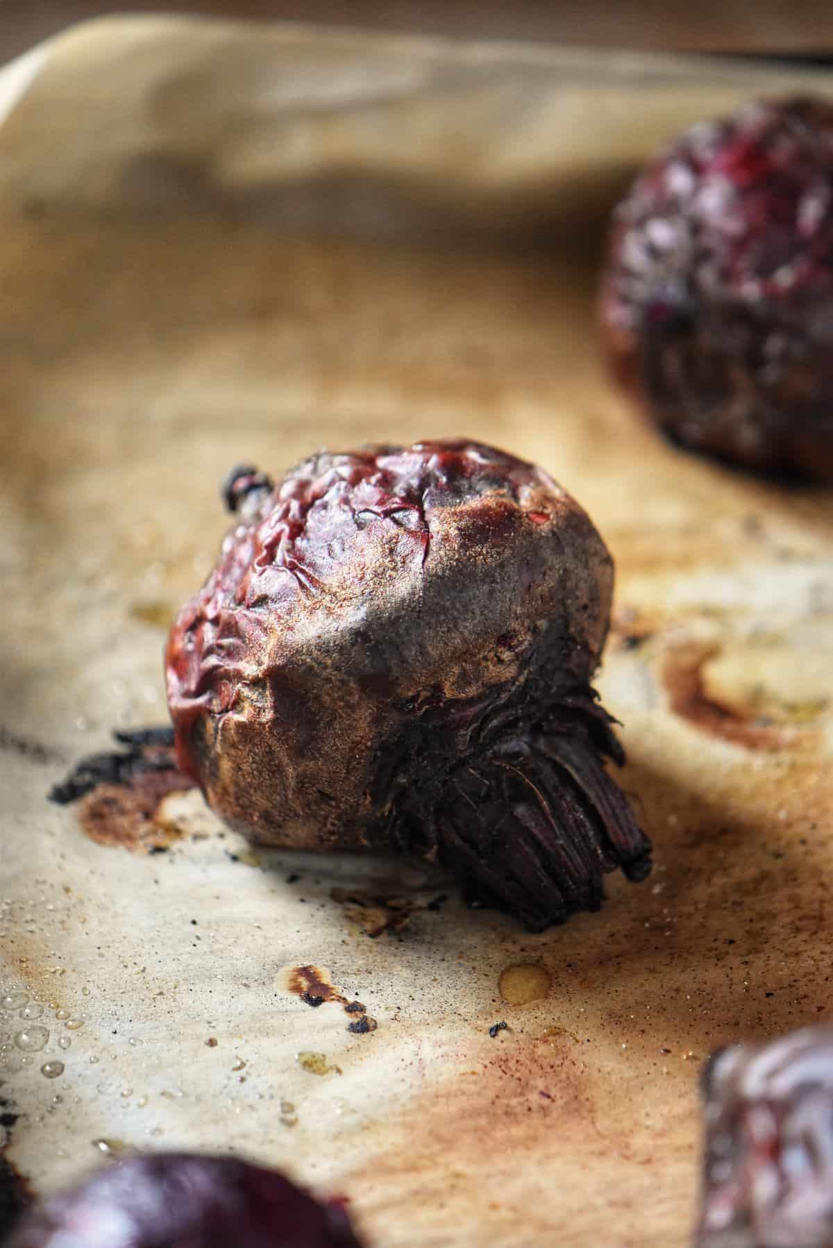 A roasted beet on parchment paper.