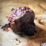 A roasted beet on parchment paper.